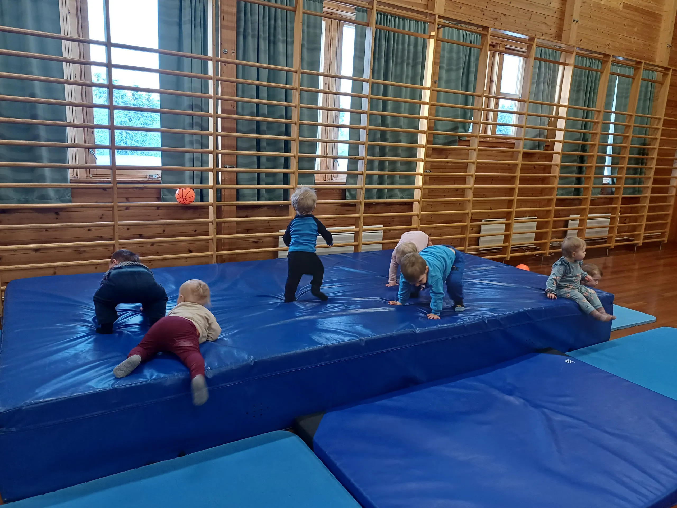 Barn leker på matter i gymsalen
